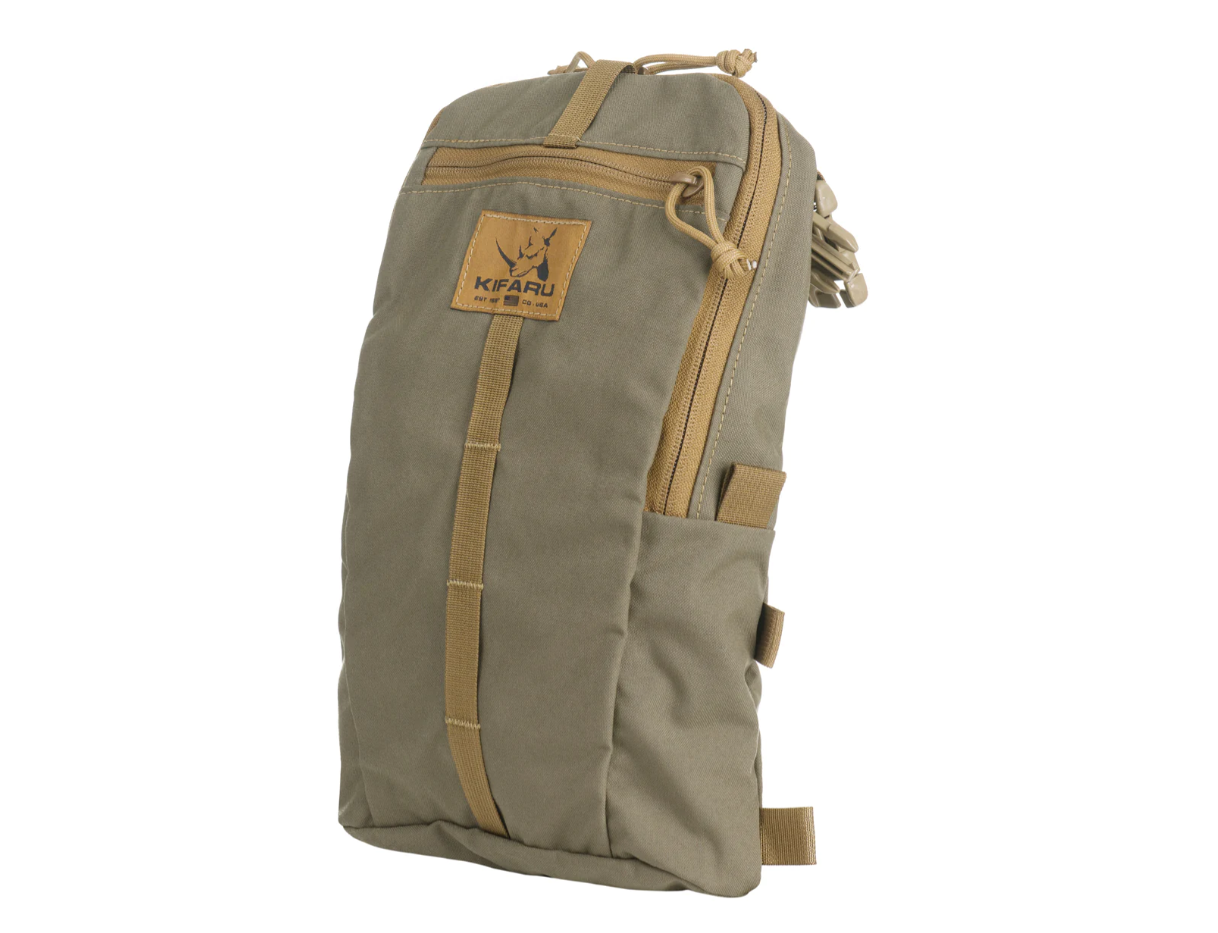 Kifaru Sherman Pocket  The Kifaru Sherman Pocket is one of the most versatile accessories in the Kifaru lineup, designed for those who demand function, durability, and adaptability in their backcountry gear. Whether you're looking to add external storage, organize critical gear, or carry awkward loads like a rifle or snowshoes, the Sherman Pocket delivers. Its intuitive attachment system allows it to connect to nearly all Kifaru packs and frames, making it a true modular asset for any hunt or extended expedition. Functioning as a compression panel, lid, rifle cradle, or lightweight training pack, the Sherman Pocket adapts to your mission. With the included straps and buckles, it can attach to areas previously reserved for a Grab It or connect directly to your frame for quick-access storage. The panel folds down when needed to create a cradle for long items—whether you’re hauling a chassis rifle or snowshoes into the high country. Built from 500D Cordura with 7oz mesh and #8 YKK water-resistant zippers, the Sherman Pocket combines lightweight design with rugged construction. Its three zippered compartments offer layered organization, while the internal mesh pocket includes a key hook for smaller valuables. With a total volume of 500 cubic inches, it provides just the right amount of space without becoming bulky. Components: Constructed from 500D DWR-coated nylon 7oz mesh and #8 YKK water-resistant zippers Three zippered compartments Internal mesh pocket with key clip Integrated rifle cradle Front slot pocket Multiple tab loops for modular attachments Includes three 30” K-clip straps and hardware for attachment Notes: Weight: 10.8 oz Dimensions: 9” W x 14” H x 2.5” D Volume: 500 cubic inches Compatible with Kifaru packs, frames, and Hellcat harness (torso dependent) Whether you're adding organized space or building out a modular rifle-carry system, the Kifaru Sherman Pocket gives you unmatched flexibility and backcountry-ready durability.