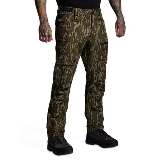 Men’s Frontier Pant 2.0 – Mossy Oak Built for serious backcountry hunters and outdoor professionals, the Frontier Pant 2.0 delivers a perfect balance of durability, comfort, and versatility. Designed to thrive in demanding environments, these pants are engineered to perform across a wide range of conditions—comfortable in 60°F weather but tough enough to handle frigid extremes when paired with a proper layering system. Constructed from a 4-way stretch fabric, the Frontier 2.0 moves with you rather than against you, ensuring unrestricted mobility when climbing ridges, crawling through brush, or kneeling for a shot. The fabric is warm yet breathable, with side-zip vents that allow you to regulate body temperature during high-exertion hunts. To enhance performance in wet or rugged terrain, the pants are finished with a durable water-repellent coating and reinforced in critical high-wear zones: the knees, seat, and heels. For extended backcountry use, the Frontier Pant 2.0 incorporates internal knee pad pockets for added protection and comfort during long glassing sessions or stalks. The pocket system is designed with hunters in mind—providing ample, versatile storage without bulk, keeping essential gear close at hand without hindering movement. Fit and comfort are equally prioritized. The athletic cut is dialed in for active hunters who demand flexibility without sacrificing durability. Whether you’re navigating rocky terrain, trekking through snow, or waiting out long hours in the stand, these pants are engineered to adapt with you. Key Features 4-way stretch fabric for mobility and durability Water-repellent finish for all-weather performance Reinforced knees, seat, and heel for longevity Side-zip vents for temperature regulation Internal knee pad pockets for added comfort Athletic fit with versatile pocket system Conditions: 60°F to Frigid