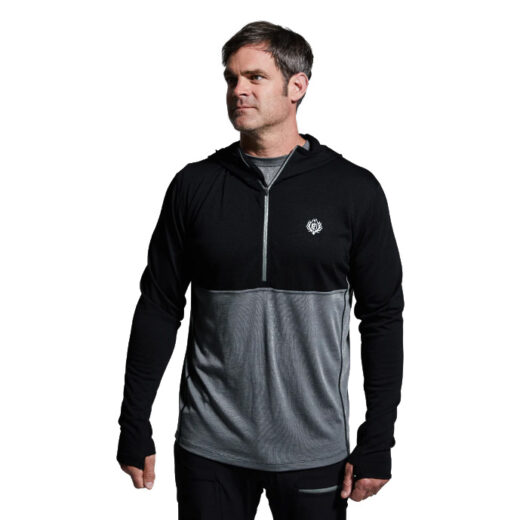 Men’s Ridgeline Half Zip Hoodie – Black The Ridgeline Half Zip Hoodie is built to be the cornerstone of your cold-weather layering system, offering premium performance from a lightweight, next-to-skin design. Crafted from a super-soft Merino wool blend, it delivers the perfect balance of warmth, moisture management, and comfort for extended use in the field. Merino’s natural properties make it one of the most versatile fibers available to hunters and outdoorsmen. It’s highly breathable, quick-drying, and antimicrobial, meaning it resists odor even after days of hard use. Unlike synthetic fabrics, Merino maintains its insulation value even when wet, keeping you warm and dry no matter how demanding the conditions. Combined with the added durability of synthetic fibers, this hoodie stands up to rugged use season after season. The half-zip design allows for easy temperature regulation—zip it up when the cold sets in or vent it quickly during strenuous climbs. A streamlined hood adds another layer of protection against wind and cold without excess bulk, making it ideal under mid and outer layers. Flatlock seams minimize chafing, while the athletic cut ensures unrestricted mobility, whether you’re glassing ridgelines, hiking deep into backcountry terrain, or sitting through long, frigid sits. Key Features: Merino Wool Blend – Soft, breathable, and naturally odor-resistant. Moisture-Wicking & Quick-Drying – Stays dry and comfortable during exertion. Half-Zip Venting – Allows quick heat release and easy layering. Streamlined Hood – Provides added warmth and coverage without bulk. Next-to-Skin Fit – Optimized for layering efficiency. Recommended Conditions: Cold to Frigid when paired with a mid layer and/or outer layer. Whether worn as a foundation piece or integrated into a full layering system, the Men’s Ridgeline Half Zip Hoodie is a must-have for serious hunters and adventurers facing unpredictable conditions.