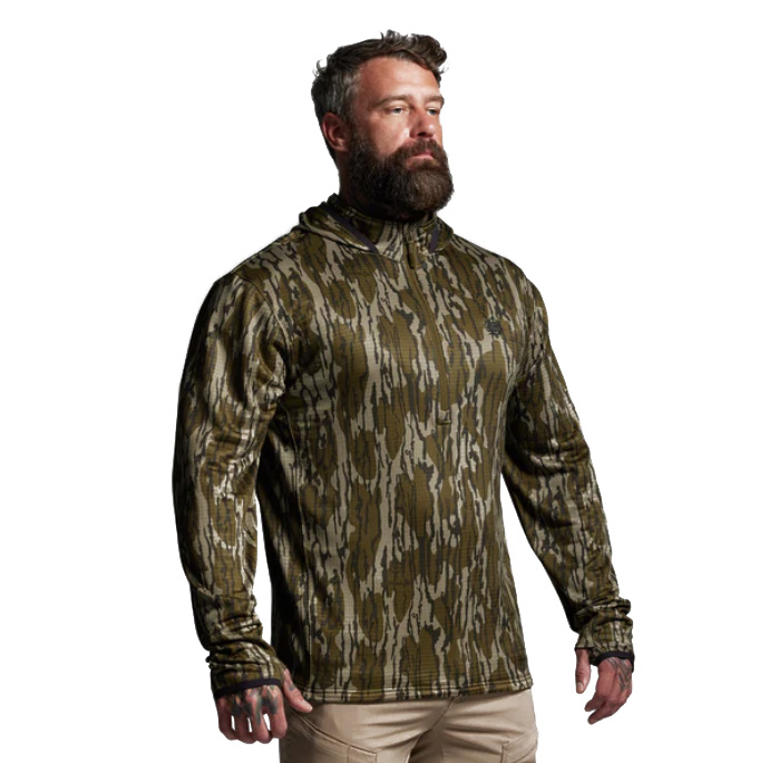 Quiver Half Zip Hoodie 2.0 – Mossy Oak® Designed for backcountry hunters who demand reliable performance across changing conditions, the Quiver Half Zip Hoodie 2.0 combines warmth, breathability, and packability in one versatile piece. Built from advanced grid fleece fabric, this hoodie delivers thermal efficiency without the excess bulk of traditional insulation, making it a true workhorse in any layering system. The grid-patterned interior is engineered to trap warm air close to the body for insulation while simultaneously allowing airflow to move through the channels. This dual-purpose design enhances breathability and moisture wicking, keeping you dry during high-output pursuits like climbing ridges, packing meat, or long hikes with a loaded kit. The result is dependable warmth when you’re stationary and effective cooling when you’re moving. A half-zip front closure provides quick and efficient temperature regulation—zip it up for added protection in biting winds or open it to dump heat during intense activity. The streamlined athletic fit layers comfortably under shells or outerwear without adding bulk, while flatlock seams minimize chafing during extended wear. Finished in Mossy Oak® camouflage, the Quiver 2.0 blends seamlessly into natural environments, giving you a stealth edge during critical moments in the field. Key Features: Grid Fleece Fabric – Lightweight warmth with enhanced airflow and moisture management. Grid Interior Design – Traps heat while promoting breathability. Half-Zip Venting – Quick regulation of body temperature. Streamlined Athletic Fit – Layers easily under mid and outer layers. Mossy Oak® Camo Finish – Proven concealment in diverse terrain. Recommended Conditions: 60°F to Frigid, when paired with the right layering system. From long days of scouting to frigid dawn hunts, the Quiver Half Zip Hoodie 2.0 – Mossy Oak® adapts to your pace, your terrain, and the elements—making it a must-have for the serious hunter.