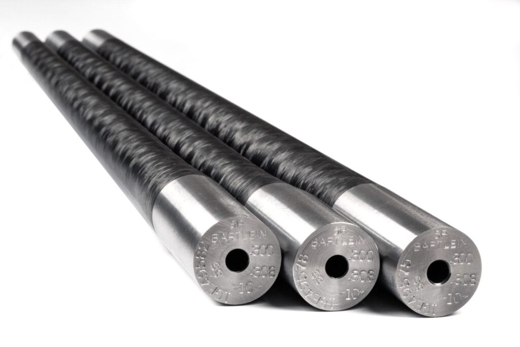 The Bartlein Carbon Fiber Wrapped Barrel Blank combines the legendary accuracy of Bartlein’s cut-rifled barrels with modern carbon fiber technology to create a lightweight yet extremely rigid barrel platform. Bartlein Barrels are widely respected throughout the precision rifle community and are used by competitive shooters, custom rifle builders, and military teams around the world. Their barrels are produced using single-point cut rifling, a process known for creating extremely uniform bore geometry while minimizing internal stress in the steel. This results in excellent consistency, repeatability, and long-term accuracy potential. Each Bartlein carbon barrel begins with a precision cut-rifled stainless steel barrel core, which is drilled, reamed, honed, and rifled to extremely tight tolerances. The barrel core is then wrapped in high-strength carbon fiber that significantly reduces overall barrel weight while maintaining rigidity. Compared to traditional all-steel barrels of similar contour, carbon wrapped barrels can provide approximately 20–25% weight reduction, making them extremely attractive for lightweight hunting rifles and backcountry builds. Bartlein carbon barrels are available in multiple calibers, twist rates, contours, and finished lengths, allowing gunsmiths to configure the barrel for specific cartridges and rifle platforms. Common contours include configurations similar to Remington Varmint/Sendero and M24/M40 profiles, which provide excellent rigidity while still maintaining reduced weight. Because these are supplied as unfinished barrel blanks, they allow a gunsmith to cut the chamber, thread the muzzle, and machine the tenon to match the exact action and cartridge specifications of the rifle being built.